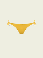 Yellow bikini bottom with string ties on a beige background