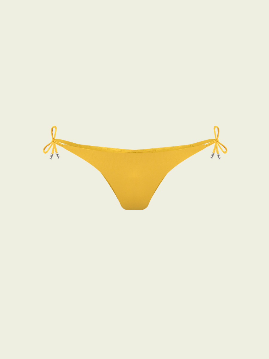 Yellow bikini bottom with string ties on a beige background