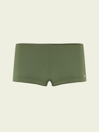 Green boxer briefs on a beige background